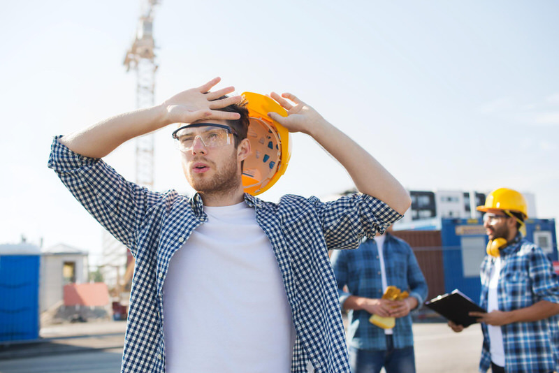Three construction workers are attempting to communicate with each other in order to figure out confusion in their current task.